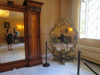 A close-up view of a cracked mirror in Empress Sisi's bedroom at the Achilleion Palace. The reflection shows the writer.